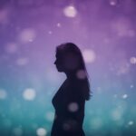 A dreamy, soft-focus silhouette of a woman standing against a gradient sky (purple to teal).